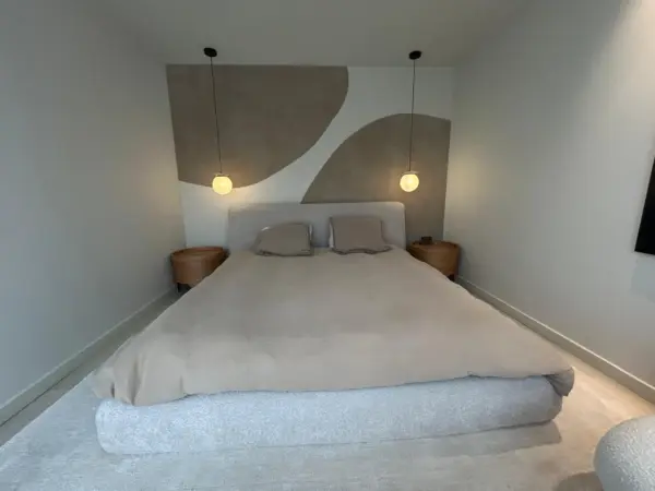 Retour du client après avoir posé le papier peint Timo dans une chambre pour un résultat moderne et élégant grâce aux deux motifs ronds beiges