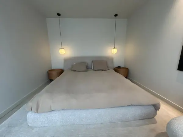 Retour client avant la pose d'un papier peint dans une chambre au mur blanc.