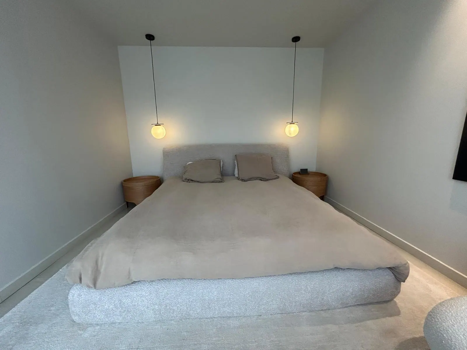 Retour client avant la pose d'un papier peint dans une chambre au mur blanc.